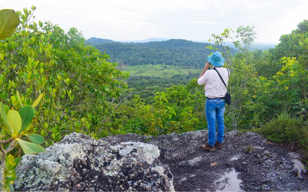 guia de turismo tomando una foto de un paisaje, turismo guaviare