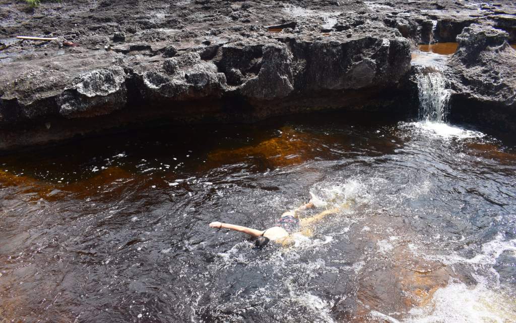 mujer nadando en las aguas de los pozos naturales en jose del guaviare