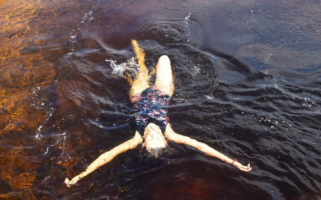 mujer nadando boca arriba en pozo natural de san jose del guaviare