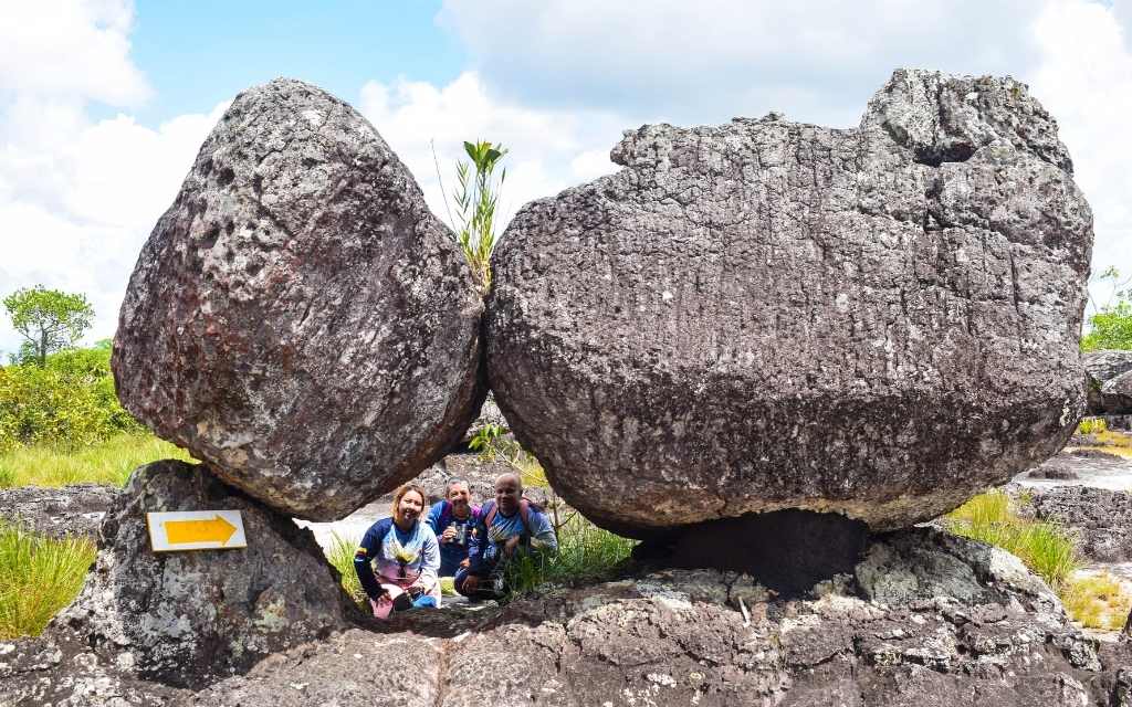 turistas asomandose en una pequeña ventana formada por rocas en san jose del guaviare