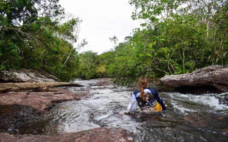 en los tuneles naturales una mujer disfruta las aguas de caño lajas en un paisaje bien bonito