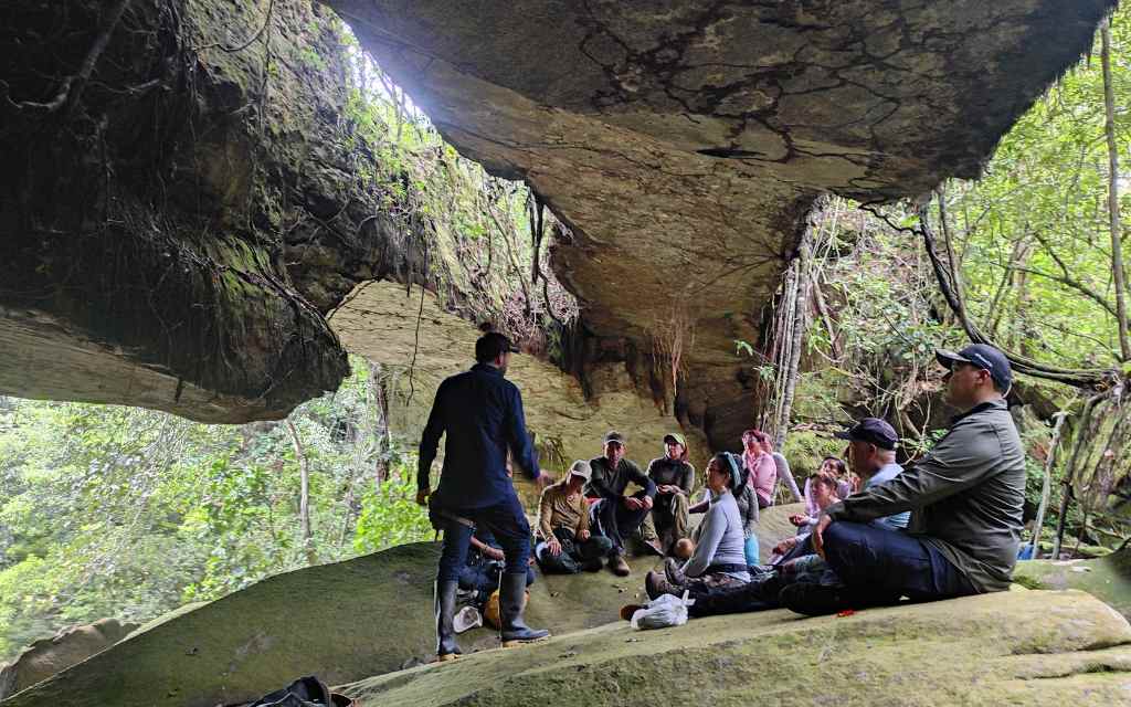 grupo de turistas meditando debajo de los puentes naturales en el guaviare